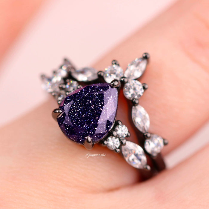 Evelyn Starry Night Ring Set in Black Ruthenium by Aquamarise featuring a pear-shaped galaxy sandstone center stone with sparkling simulated diamonds on a black rhodium sterling silver band.