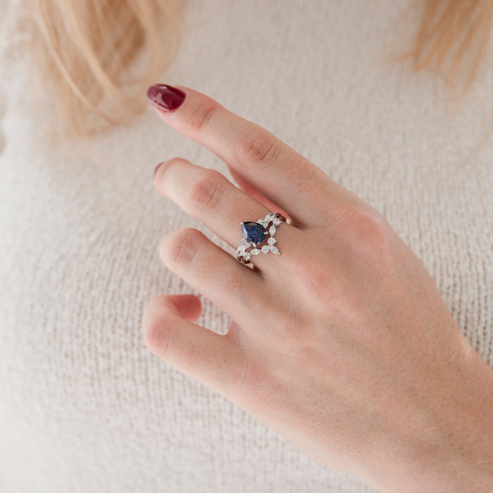 Evelyn Starry Night Engagement Ring Set in 14K White Gold by Aquamarise Gold, featuring a pear-shaped deep blue stone with sparkling diamond accents in a celestial-inspired design.