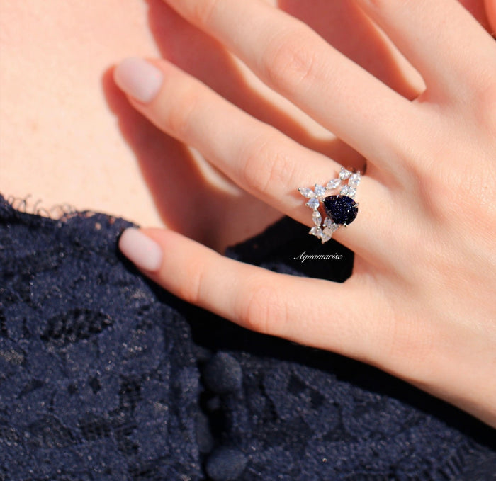 Evelyn Starry Night Engagement Ring Set in 14K White Gold by Aquamarise Gold featuring a pear-shaped deep blue gemstone and star-inspired diamond accents in a celestial design.