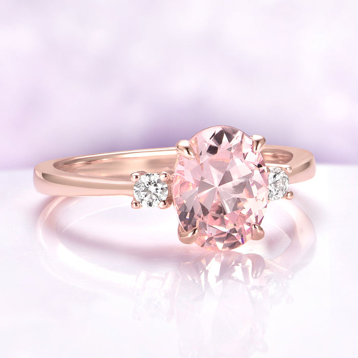 Everly Three Stone Oval Morganite Ring in 14K Rose Gold Vermeil by Aquamarise, with a 2 carat oval simulated morganite center and two simulated diamond side stones.