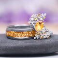 Fantasy Cut Citrine Couples Ring Set by Aquamarise, showcasing a silver band with a radiant star-cut citrine center stone surrounded by delicate leaf accents, paired with a dark band inlaid with crushed natural citrine, part of Matching Couples' Rings and Fantasy-Inspired Jewelry collections.