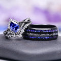 Faye Galaxy Orion Nebula™ & Sapphire Couples Ring Set by Aquamarise featuring an intricate silver ring with a deep blue sapphire surrounded by sparkling accents paired with a black finish band inlaid with shimmering blue and silver details.
