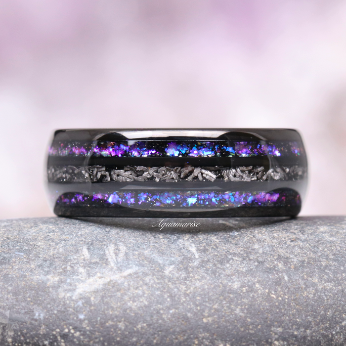 Faye Galaxy Orion Nebula™ & Sapphire Couples Ring Set featuring a polished black finish band inlaid with vivid blue and purple sapphire flakes and textured metallic accents, crafted by Aquamarise as part of Matching Couples' Rings and Orion Nebula Rings® collections.