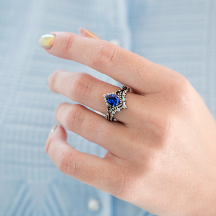 Faye Galaxy Orion Nebula™ & Sapphire Couples Ring Set featuring a pear-shaped blue sapphire center surrounded by delicate sparkling stones on a black-finished band, by Aquamarise, part of Matching Couples' Rings and Sapphire Jewelry collections.