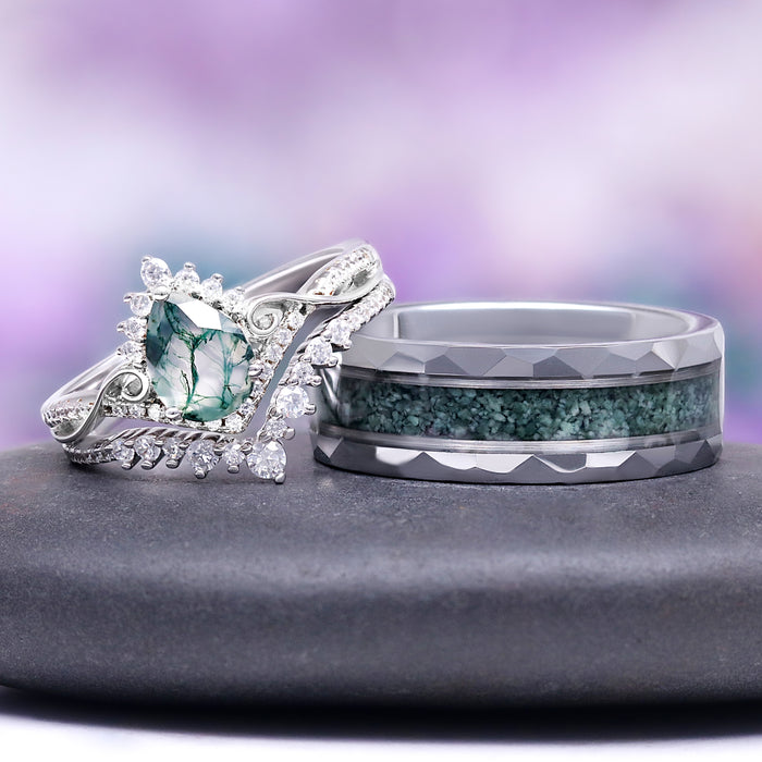 Two rings with green gemstones on a gray surface against a purple gradient background