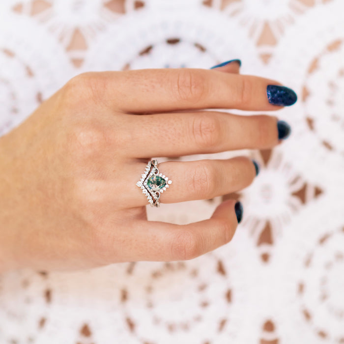Close-up of a hand wearing the Faye Green Moss Agate Engagement Ring Set in Sterling Silver by Aquamarise, featuring a pear-shaped green gemstone with unique natural inclusions.