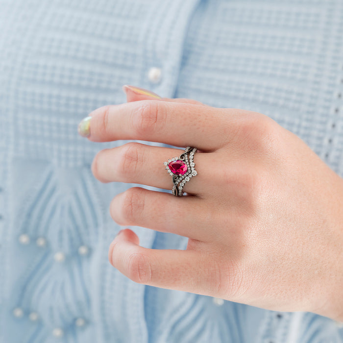 Faye Ruby Engagement Ring Set in Black Ruthenium by Aquamarise features a pear-shaped ruby center framed by sparkling simulated diamond accents on a sleek black ruthenium band, part of July Birthstone Jewelry and Women’s Black Rings collections.