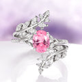 Fireworks Cut Pink Sapphire Leaf Engagement Ring in 14K White Gold by Aquamarise Gold, featuring an oval lab-grown pink sapphire with intricate leaf-inspired white gold detailing and sparkling diamond accents, part of Solid Gold Engagement Rings and Nature-Inspired Engagement Rings collections.