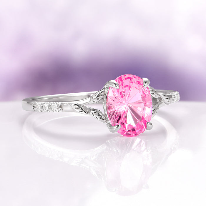 Fireworks Cut Pink Sapphire Leaf Engagement Ring in 14K White Gold by Aquamarise Gold showcasing an oval lab-grown pink sapphire with delicate leaf-inspired white gold details and sparkling diamond accents, part of Solid Gold Engagement Rings and September Birthstone Jewelry collections.