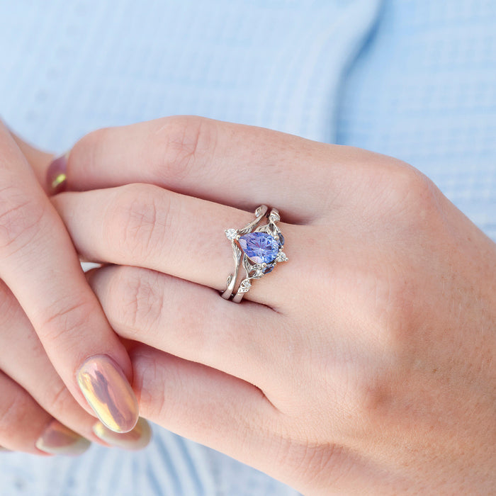 Fireworks Cut Lab-Grown Lavender Sapphire Engagement Ring Set in 14K White Gold showcasing a pear-shaped star-cut lavender sapphire framed by delicate vine-like white gold detailing with small diamond accents by Aquamarise Gold.