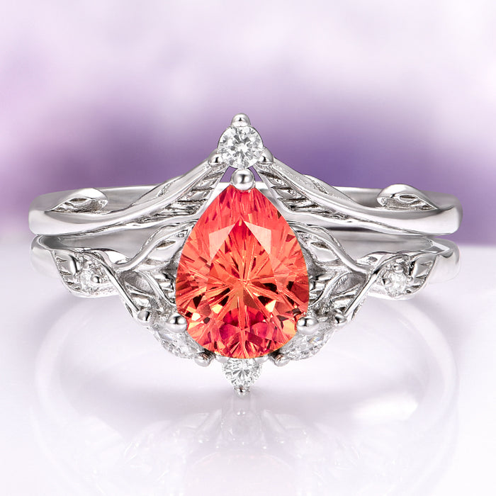 Fireworks Cut Padparadscha Sapphire Engagement Ring Set in 14K White Gold by Aquamarise Gold featuring a pear-shaped fiery padparadscha sapphire centerpiece with detailed leaf-inspired white gold band and diamond accents, part of Solid Gold Engagement Rings and September Birthstone Jewelry collections.