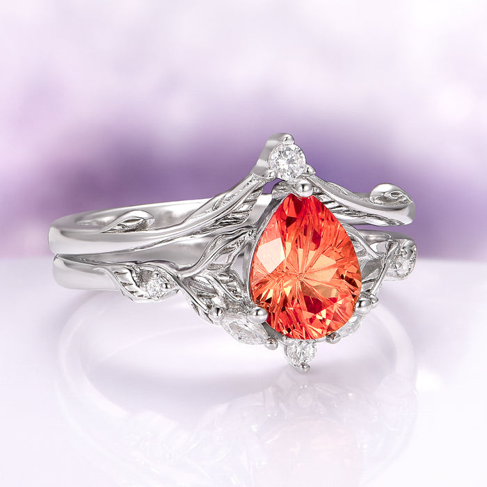 Fireworks Cut Padparadscha Sapphire Engagement Ring Set in 14K White Gold by Aquamarise Gold featuring a fiery pear-shaped sapphire with delicate leaf-like white gold band and diamond accents, part of Solid Gold Engagement Rings and September Birthstone Jewelry collections.