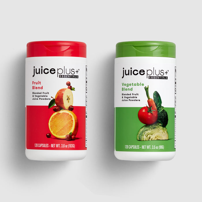 Two Juice Plus+ supplement containers, one for fruit blend and one for vegetable blend, on a light gray background.
