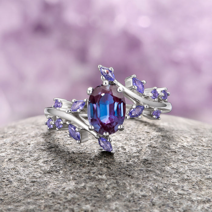 Galaxy Alexandrite Leaf Couples Ring Set featuring a central oval-cut alexandrite gemstone surrounded by delicate marquise and round purple stones arranged on a silver band with leaf-inspired accents, offered by Aquamarise.