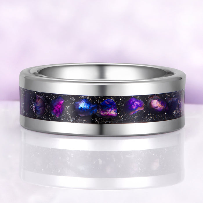 Silver ring with galaxy-themed inlay on a light purple background