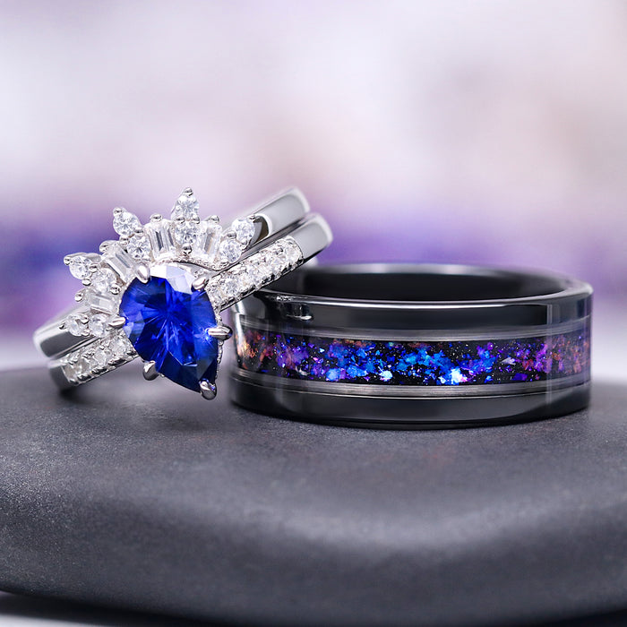Galaxy Orion Nebula™ and Blue Sapphire Couples Ring Set featuring a pear-shaped blue sapphire with diamond accents and a black band with shimmering cosmic inlay by Aquamarise.