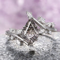 A sterling silver ring featuring a kite-cut Herkimer diamond with salt and pepper inclusions, accompanied by smaller clear stones on the band.