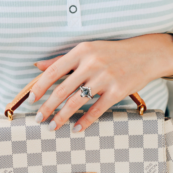 Hand wearing the Galaxy Salt & Pepper (Herkimer) Diamond & Meteorite Couples Ring Set by Aquamarise, featuring a unique coffin cut diamond ring with a bold hammered silver band, resting on a checked designer handbag.