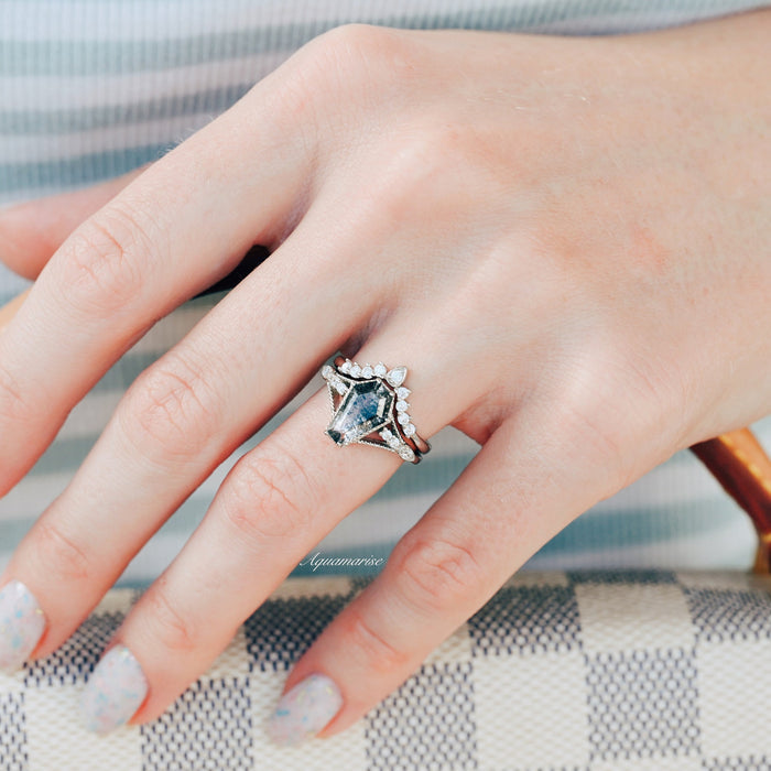 Hand showcasing the Galaxy Salt & Pepper (Herkimer) Diamond & Meteorite Couples Ring Set by Aquamarise, featuring a striking coffin-cut diamond surrounded by delicate accent stones, styled holding a checkered handbag.