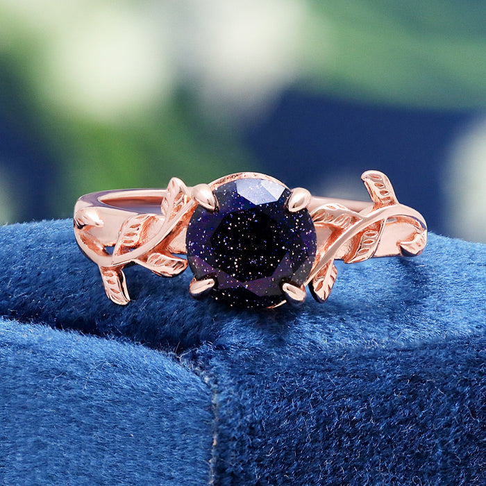 Rose gold vermeil leaf ring on blue velvet, showing the glitter within the galaxy sandstone