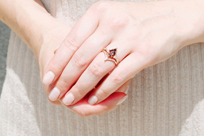 Garnet & Red Fire Opal Whiskey Barrel Couples Ring Set by Aquamarise featuring a kite-cut garnet with diamond accents in rose gold on a hand, elegant matching couples rings.