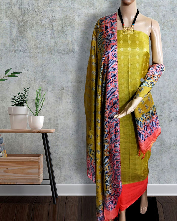Gold yellow Katan silk unstitched suit set with a small geometric printed tunic, a multicolour paisley and diagonal striped dupatta, and solid red bands at both hems