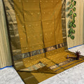 Golden mustard yellow Maheshwari silk saree with small gold buti and metallic borders edged in dark brown, handwoven in Maheshwar