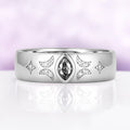 Close view of the gray moissanite celestial band showing the milgrain-edged crescents, star accents and polished dome profile