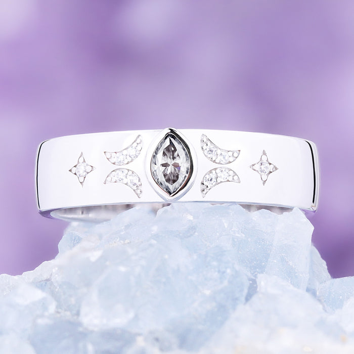 Gray moissanite celestial wedding band in sterling silver on blue crystal, bezel-set marquise between pave crescent moons and stars