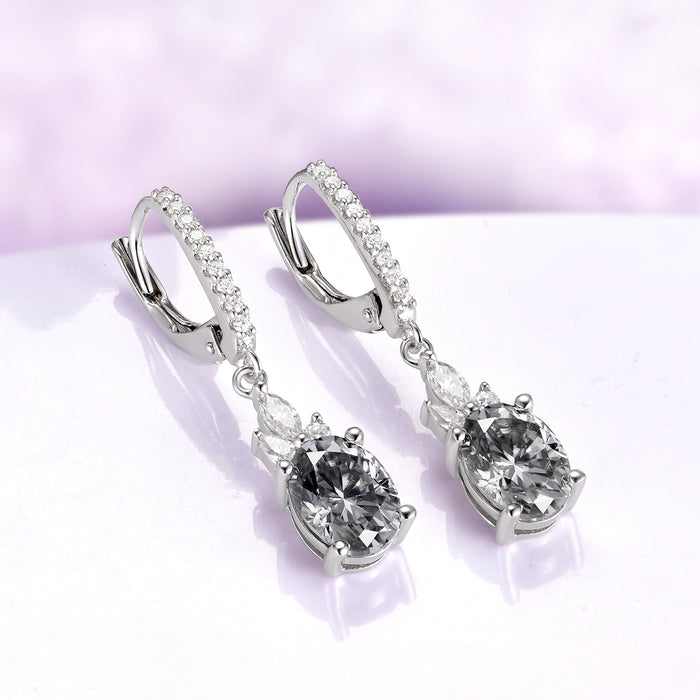 Gray Moissanite Earrings Oval Moissanite Drop Earrings over a light purple background