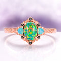 Green Fire Opal Leaf Engagement Ring in 14K Rose Gold Vermeil featuring a vibrant green fire opal center, opalescent side stones, and intricate leaf engraving by Aquamarise.