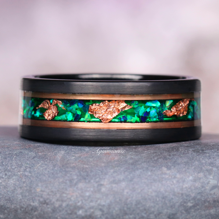Green Fire Opal & Moss Agate Leaf Couples Ring Set by Aquamarise featuring a black band with vibrant green opal and moss agate inlay accented by copper leaf details, symbolizing nature-inspired love.
