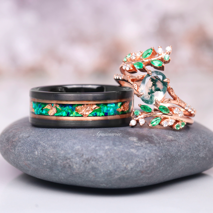 Emerald Leaf Ring Guard in 14K Solid Rose Gold by Aquamarise Gold featuring intricate vine and leaf details with lab-grown emeralds, paired with a bold black ring inlaid with green and copper accents.