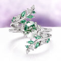 Moss Agate & Emerald Fairy Leaf Couples Ring Set by Aquamarise featuring a nature-inspired sterling silver band with a moss agate center stone, accented with emerald and sparkling clear gemstones, part of Matching Couples’ Rings and May Birthstone Jewelry collections.