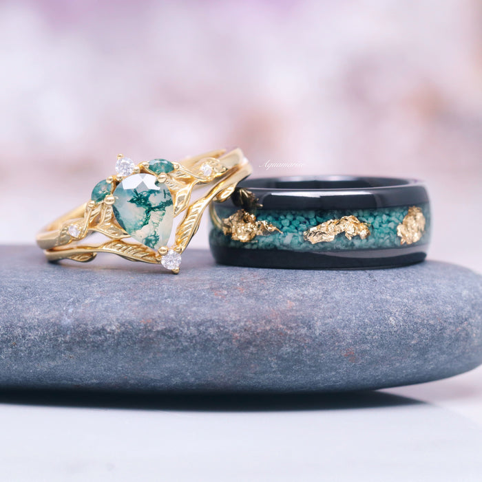 Green Moss Agate Leaf Engagement Ring Set in 14K Solid Yellow Gold featuring a pear-shaped moss agate with intricate leaf and feather details alongside a black band with green and gold accents, by Aquamarise Gold.