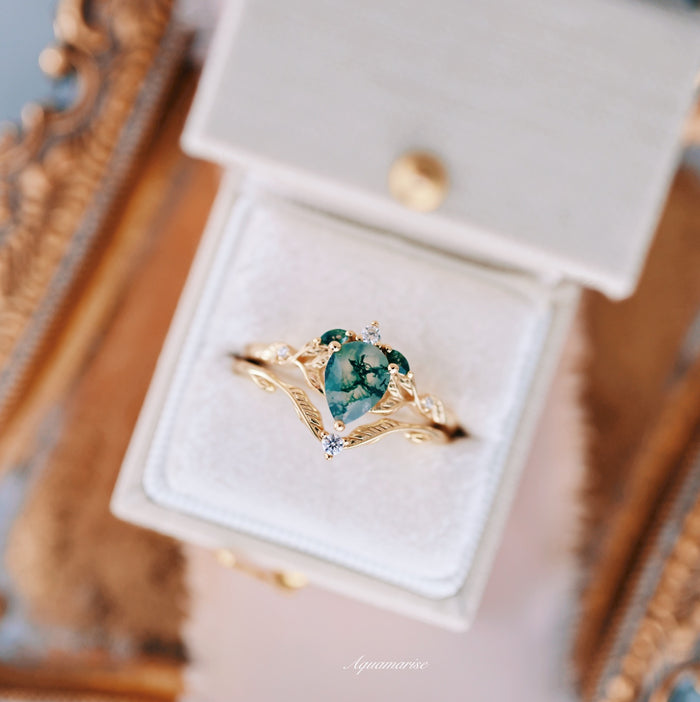 Green Moss Agate Leaf Engagement Ring Set in 14K Solid Yellow Gold by Aquamarise Gold, featuring a pear-shaped green moss agate with intricate feather-inspired gold details and delicate diamond accents in a nature-inspired design.