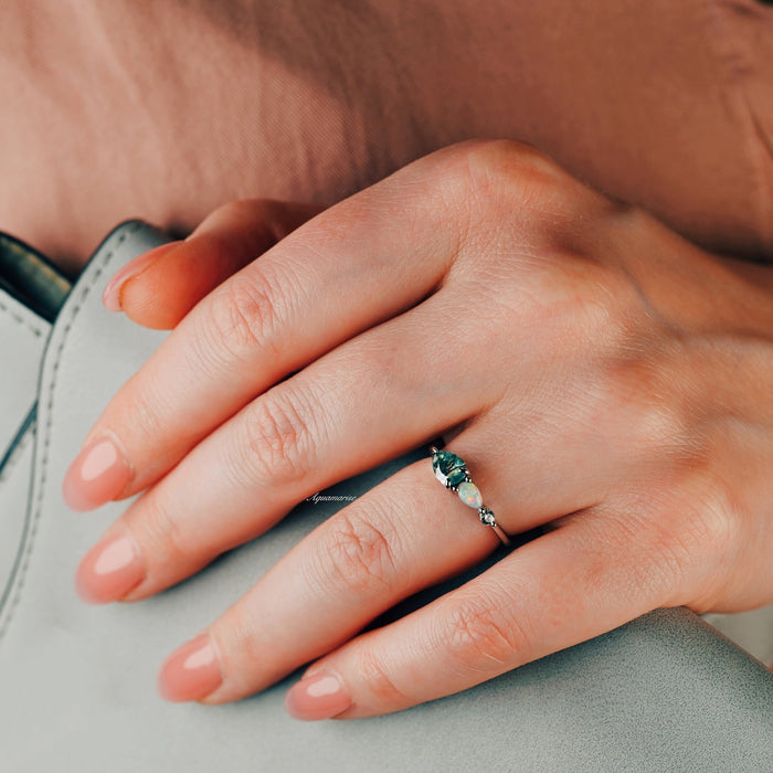 Green Moss Agate & Natural Australian Fire Opal Ring in Sterling Silver by Aquamarise shown on hand, with pear-shaped green moss agate, white fire opal, and sparkling simulated diamond accents.