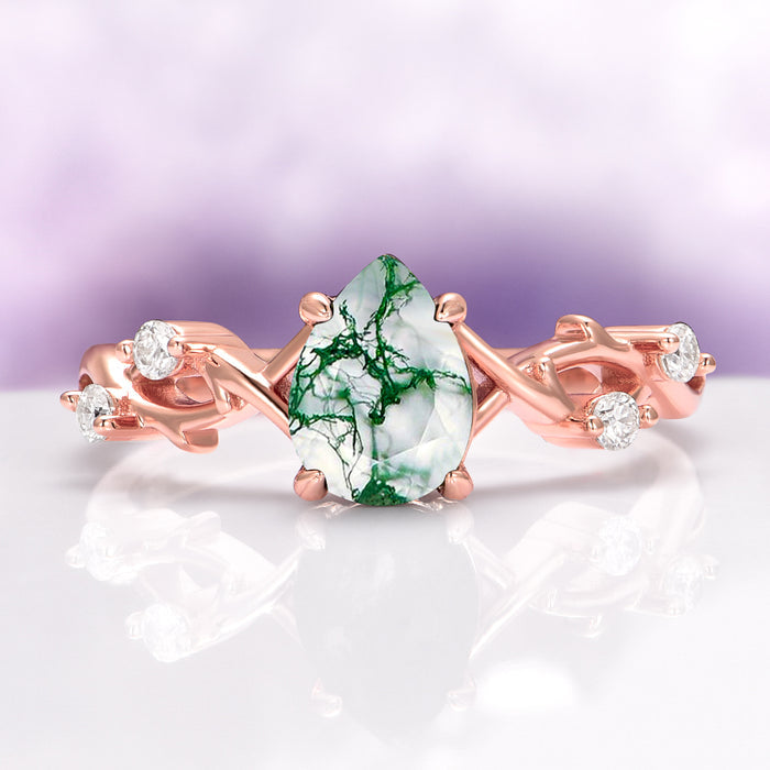 Green Moss Agate Twig Ring in 14K Rose Gold Vermeil featuring a pear-shaped moss agate stone with deep green veins and delicate twig-inspired band accented with sparkling stones.