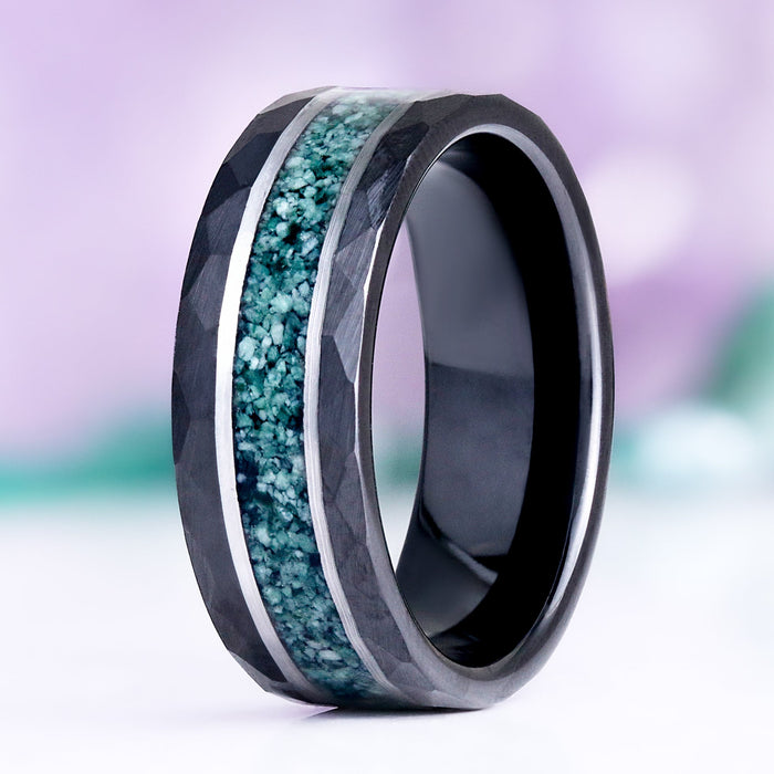Green Moss Agate hammered men's wedding band in black and silver tungsten standing upright, showing the crushed moss agate inlay between silver rails