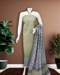 Grey Katan silk unstitched suit set with small paisley block print on the top, polka dot print on the remaining pieces in orange, green and black, and a linear band at the dupatta edge