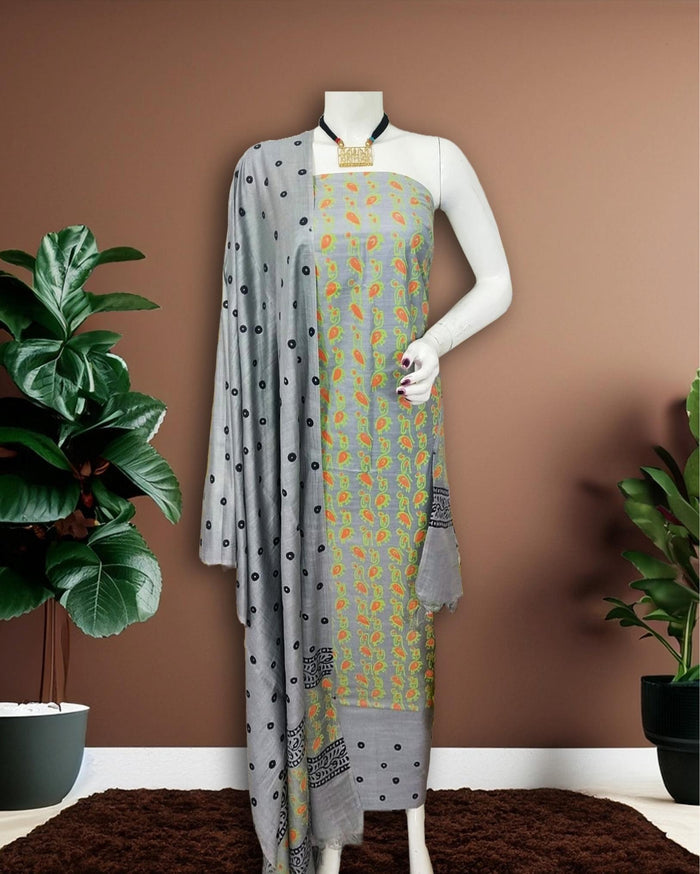 Grey Katan silk unstitched suit set with small paisley block print on the top, polka dot print on the remaining pieces in orange, green and black, and a linear band at the dupatta edge
