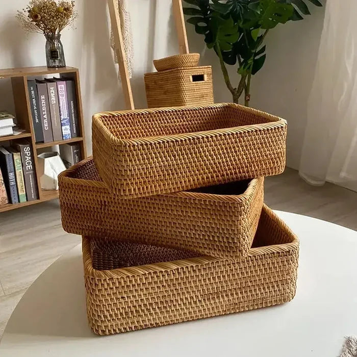 Handwoven rattan storage basket set stacked on a table, showcasing natural texture and organization.