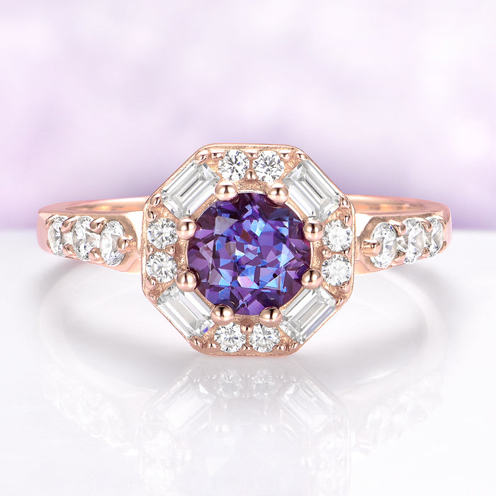 Rose gold ring with a purple gemstone and diamond accents on a light purple background