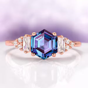 Hexagon Cut Lab-Grown Alexandrite Ring in 14K Rose Gold Vermeil by Aquamarise, showcasing a vibrant hexagonal alexandrite center stone accented with baguette and round white gemstones on a polished rose gold vermeil band, from Rose Gold Vermeil Rings, June Birthstone Jewelry, and Engagement Rings for Women collections.