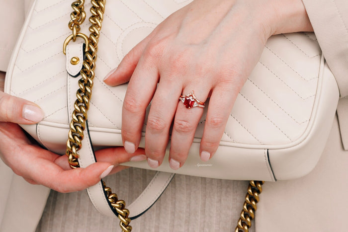 Hexagon Ruby Engagement Ring Set in 14K Solid Rose Gold by Aquamarise Gold, featuring a striking hexagon-cut ruby with diamond accents, styled on a hand holding a cream leather bag with gold chain.
