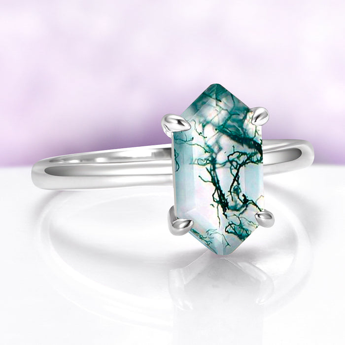 Silver ring with a unique green and white stone on a light purple background