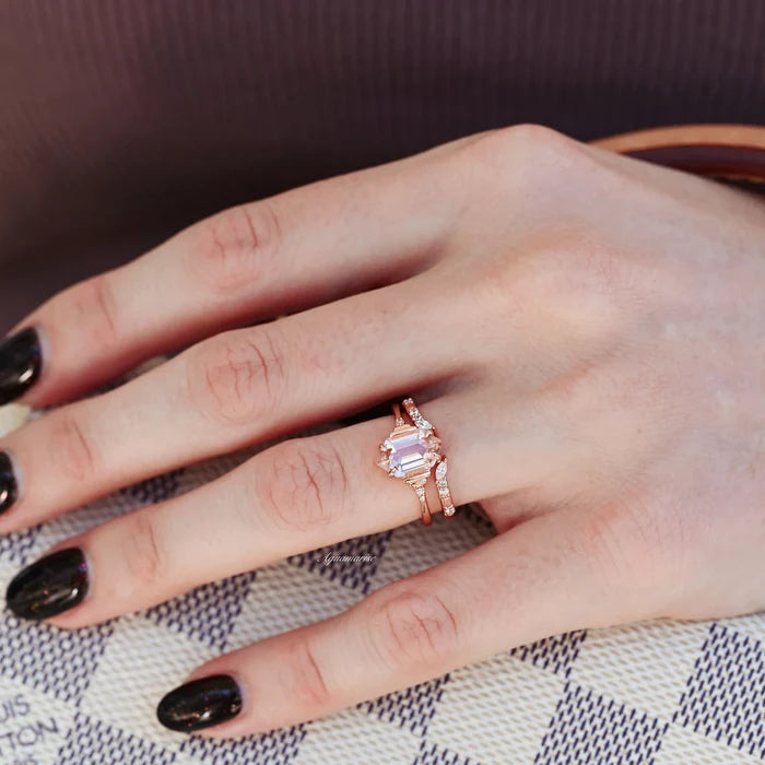 Hexagon Morganite Couples Ring Set by Aquamarise, featuring rose gold bands with a blush pink hexagonal morganite center and delicate accent stones on a hand over designer handbag.
