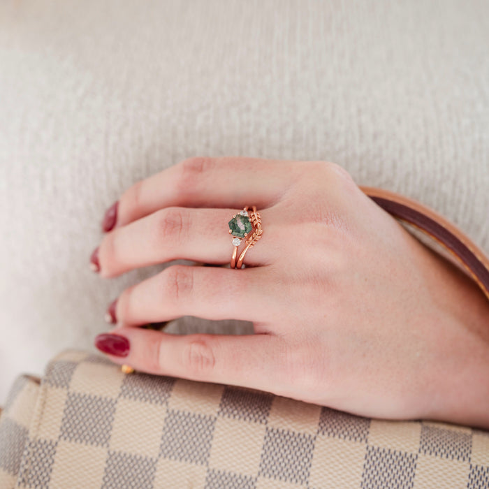 Natural Hexagon Moss Agate Engagement Ring Set- 14K Rose Gold Vermeil featuring a hexagon moss agate stone with rose gold bands worn on a hand holding a checkered handbag by Aquamarise.