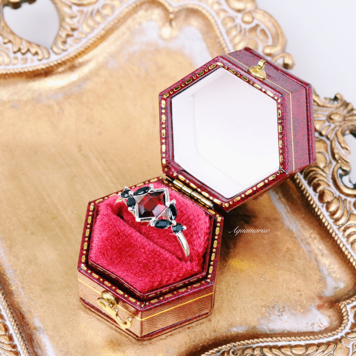 Hexagon Natural Red Garnet & Black Onyx Engagement Ring in 14K White Gold nestled in a vintage hexagonal red velvet box by Aquamarise Gold, set on an ornate golden tray.