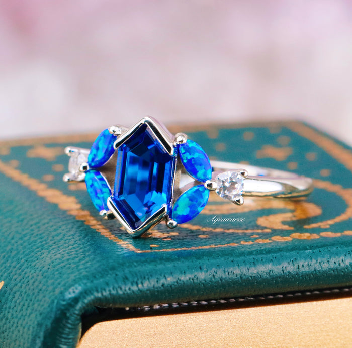 Blue Fire Opal & Sapphire Engagement Ring- Sterling Silver featuring a geometric sapphire center, marquise blue fire opals, and clear accents in a delicate silver setting by Aquamarise.